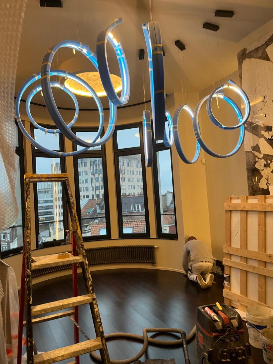 Suspension d'éclairage led circulaire installée dans une pièce en rénovation avec parquet sombre