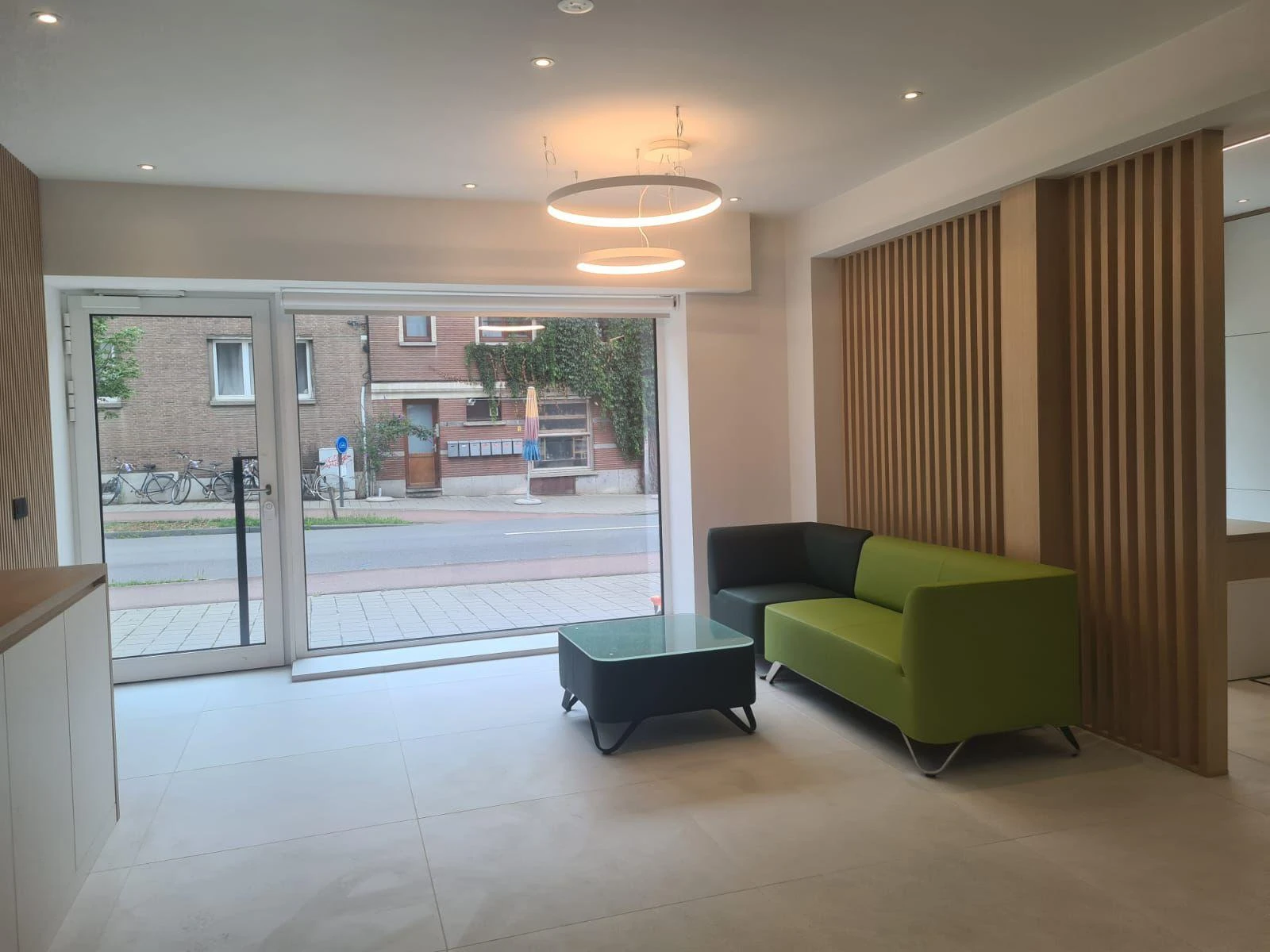 Salon moderne avec canapé vert et gris, table basse et faux plafond intégré, Éclairage led